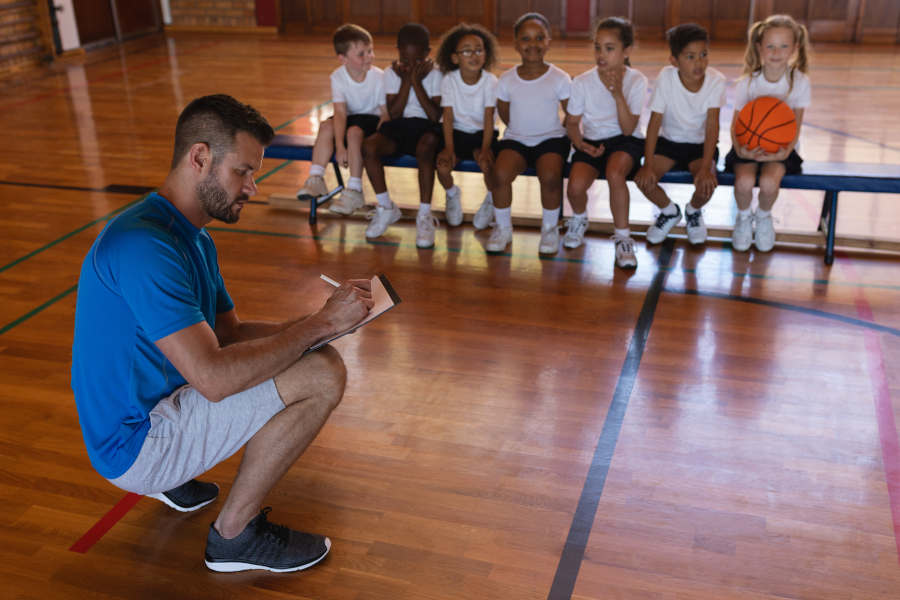 Der Coach erklärt den KIndern die Regeln im Basketball