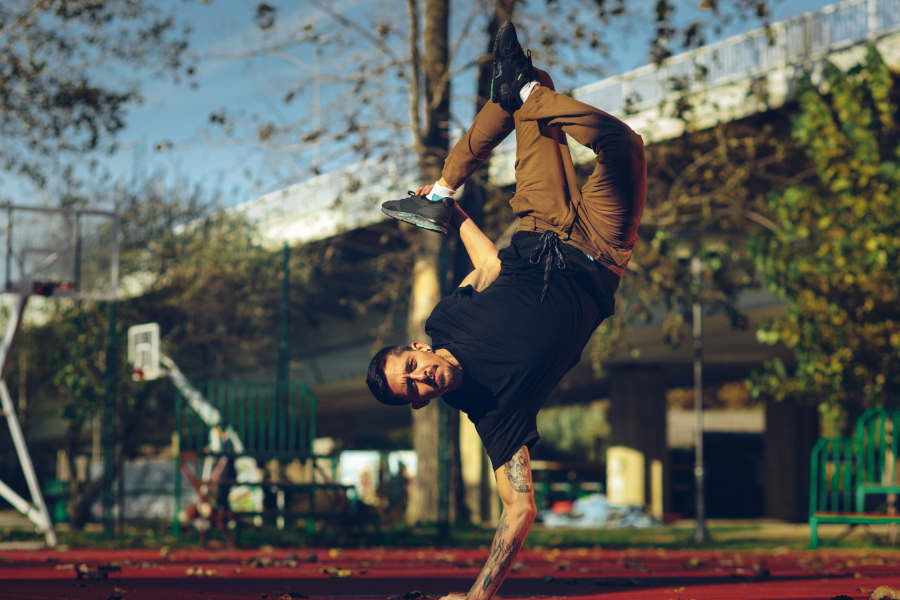 Mann macht Breakdance auf dem Basketballfeld