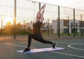 Eine Frau macht Yoga auf dem Streetballfeld