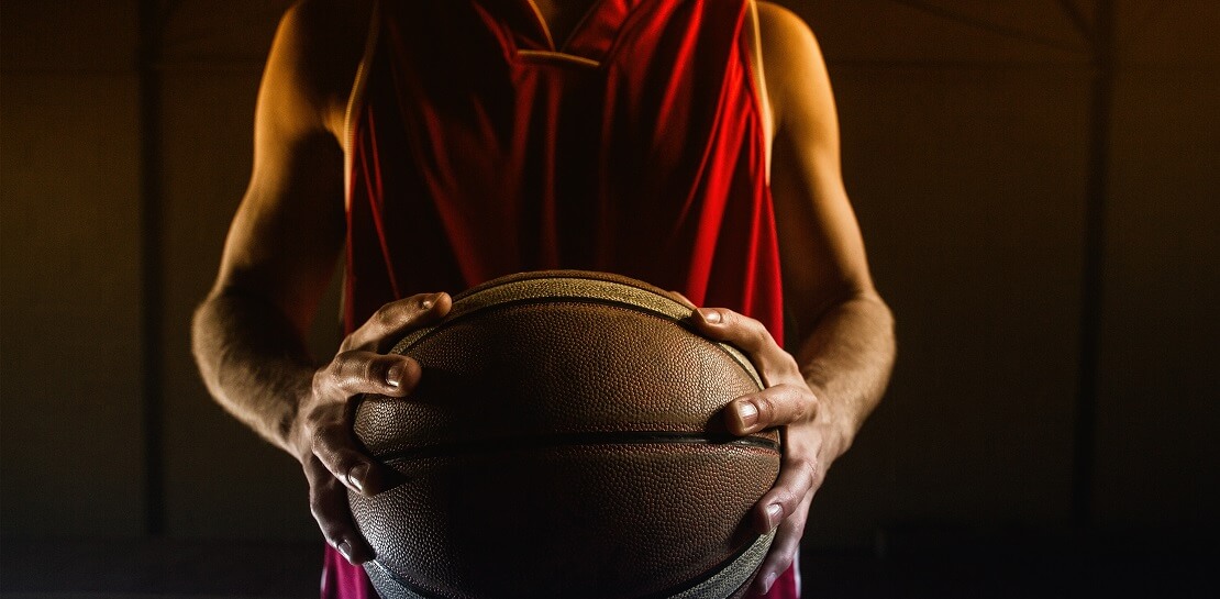 Basketballer hält den Ball fest in den Händen