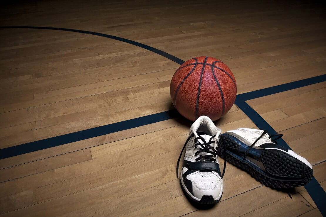 Ball und Schuhe liegen auf dem Hallenboden