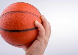 Eine Babyhand greift einen kleinen Basketball