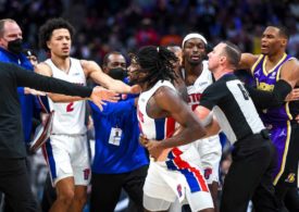 Basketballspieler rangeln und werden von Betreuern und Schiedsrichtern zurückgehalten