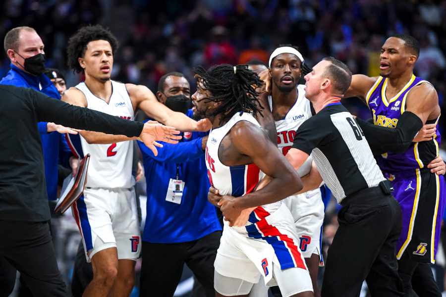 Basketballspieler rangeln und werden von Betreuern und Schiedsrichtern zurückgehalten