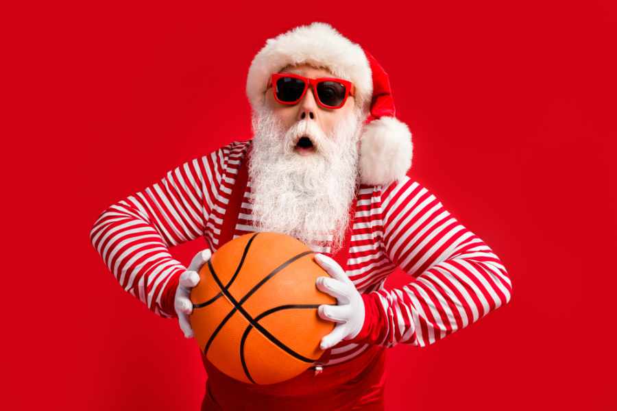 Weihnachtsmann mit einem Basketball in der Hand