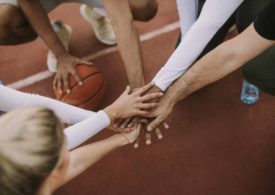 Ein Basketball Team hält ihre Hände aufeinander in die Mitte
