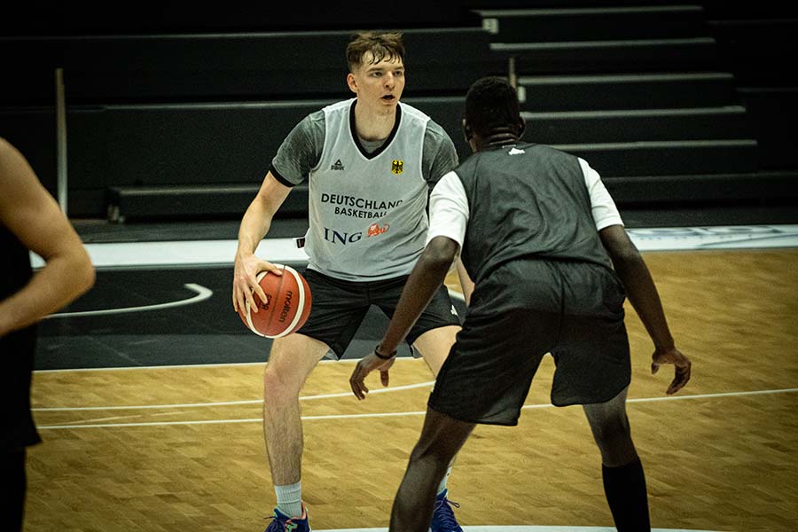 Justus Holatz mit Basketball in der Hand, vor ihm ein anderer Spieler