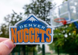 Denver Nuggets Logo, im Hintergrund ein Basketballkorb