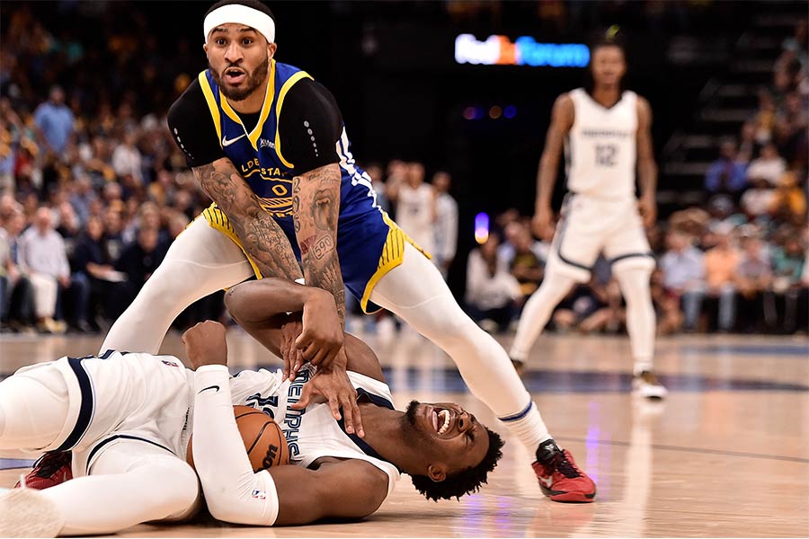 Gary Payton II steht über einem auf dem Boden liegenden Memphis Grizzlies Spieler.