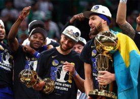 Steph Curry und Klay Thompson halten beide eine Trophäe.