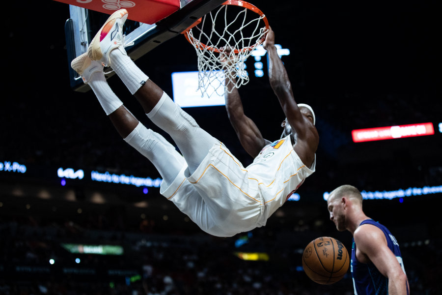 Ein Basketballspieler hängt nach dem Slamdunk am Korb