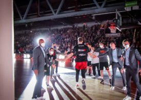 Ein Basketballspieler kommt in die Halle und klatscht mit Funktionären ab