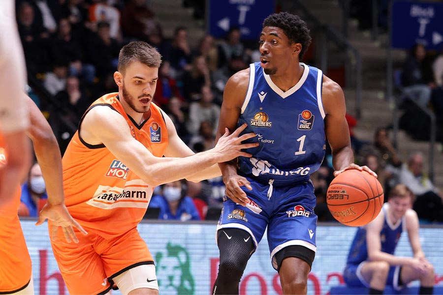 Die Basketballspieler Lukas Wank und Marcus Lewis spielen gegen einander Basketball