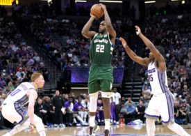 Khris Middleton wirft, bedrängt von zwei Gegenspielern, den Ball
