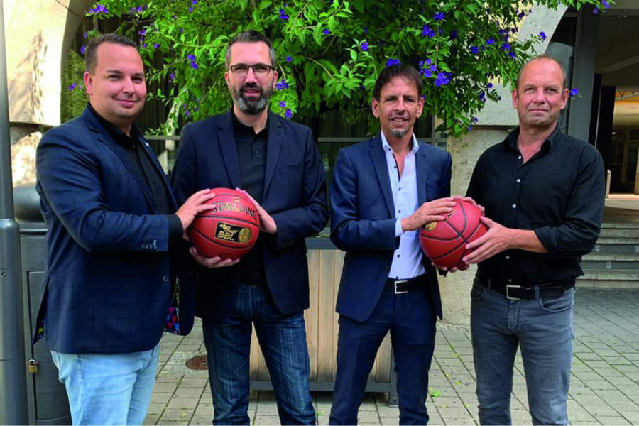 Vier Sportfunktionäre mit Basketbällen