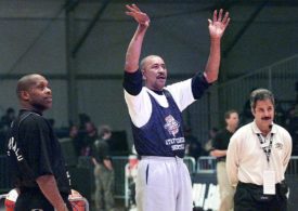 Der Basketballspieler Geroge Gervin steht wischen zwei andern Männern