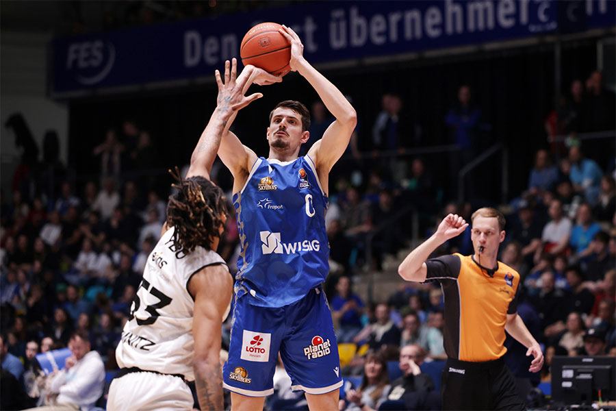 Der Basketballspieler Lukas Wank springt in die Luft mit dem Basketball in beiden Händen