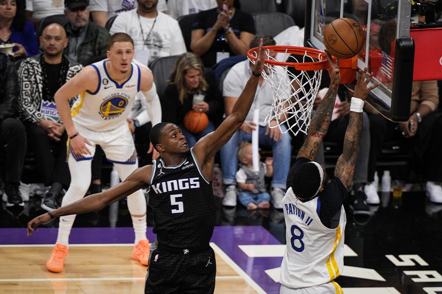 Der Basketballspieler DeAaron Fox von den Kings springt hoch zum Basketballkorb um den Ball vom gegnerischen Spieler abzublocken