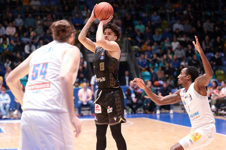 Drei Basketballspieler spielen gegen einander Basketball