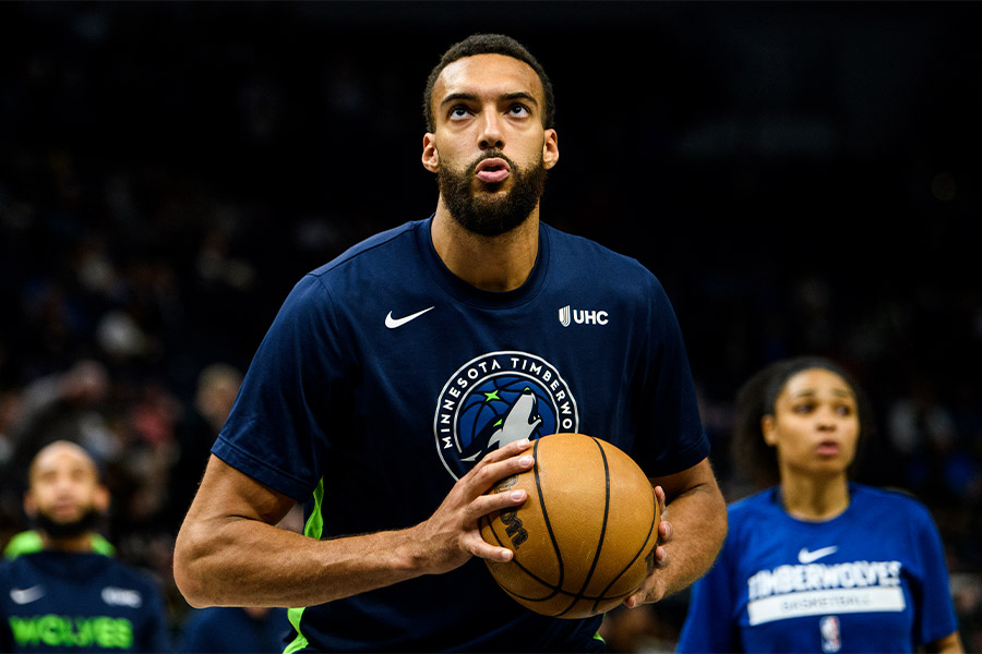 Der Basketballspieler Rudy Gobert von der Mannschaft Minnesota Timberwolves hält ein Basketball in beiden Händen fest