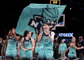 Die Basketballspielerin Han Xu von den New York Liberty steht im Vordergrund und freut sich und klatscht dabei in die Hände und im Hintergrund ist ihre Mannschaft zu sehen