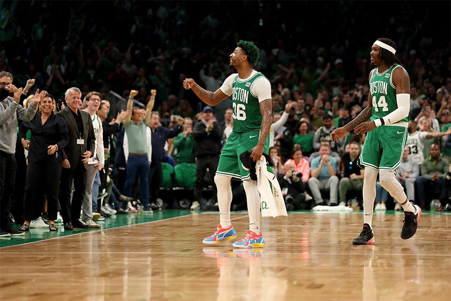 Die Basketballspieler Marcus Smart und Robert Williams von der Mannschaft Boston Celtics schauen links zur den Zuschauern, die sie an jubeln.