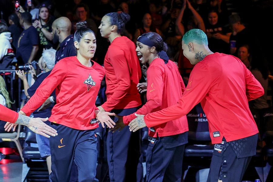 Die Basketballspielerin Kelsey Plum von den Las Vegas Aces geht an ihren Spielkameradinnen vorbei und gibt ihnen ein High Five