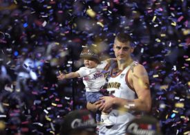 Der Basketballspieler Nikola Jokic von der Mannschaft Denver Nuggets steht mit seinem Sohn im Konfettiregen