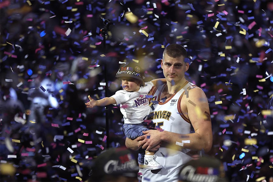 Der Basketballspieler Nikola Jokic von der Mannschaft Denver Nuggets steht mit seinem Sohn im Konfettiregen