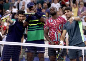 Sebastian Yatra, Jimmy Butler, Frances Tiafoe und Carlos Alcaraz posieren hinter einem Tennisnetz
