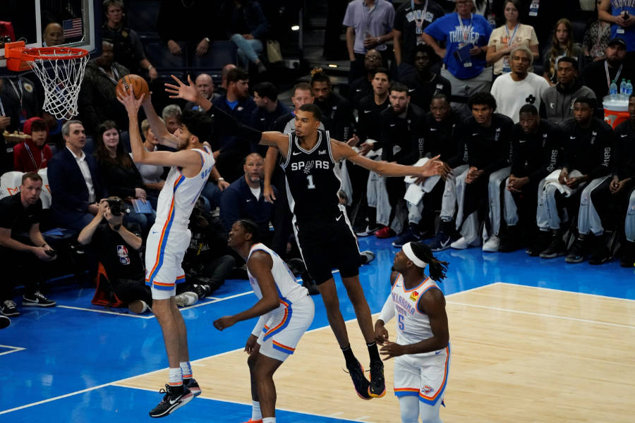 Ein Basketballspieler versucht den Dunking, ein anderer will ihn blocken