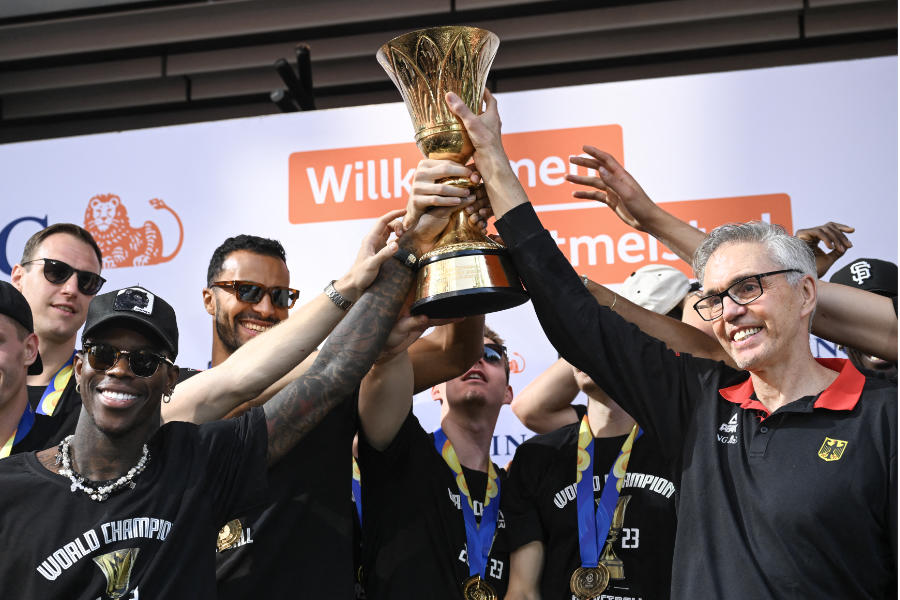 Der Bundestrainer und die Spieler der deutschen Basketball-Nationalmannschaft heben den WM Pokal in die Höhe