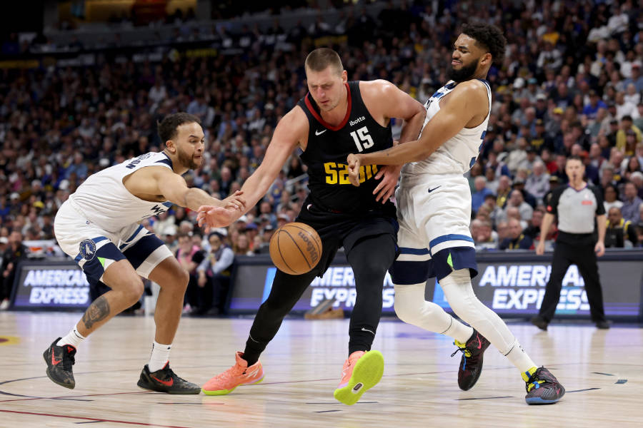 Nikola Jokic von den Denver Nuggets dribbelt gegen zwei Gegenspieler von den Minnesota Timberwolves